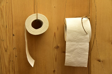 Toilettenpapier hängt an einer Holzwand