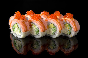 Sushi roll (Geisha) with fire-scorched salmon, sea bass, shrimp, avocado scallop, caviar, philadelphia cheese, unagi sauce on black background. Sushi menu. Japanese food.