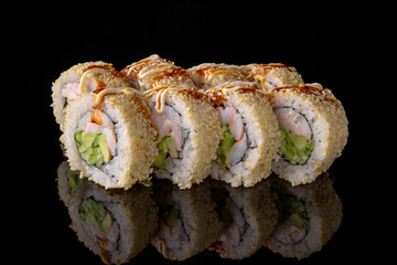 Sushi roll with shrimp, perch, avocado, unagi sauce on black background. Sushi menu. Japanese food.