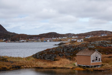 Fototapeta na wymiar Small town on the Atlantic Ocean Coast during a cloudy morning. Goose Cove East, Saint Anthony, Newfoundland, Canada.