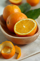 Oranges in a wooden bowl with leaves