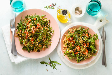 rice salad with baked bell peppers, arugula, olives and capers. Healthy vegan spring recipe for the whole family or party