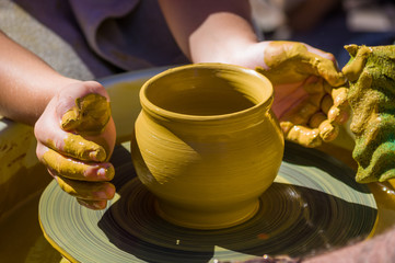 hands of the skilled master Potter and children's hands, training of the kid to production of pottery on a Potter's wheel