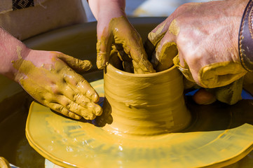 hands of the skilled master Potter and children's hands, training of the kid to production of pottery on a Potter's wheel