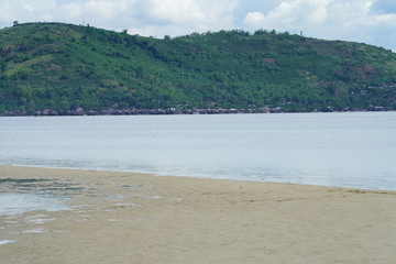 View of Manjuyod Sandbar, Philippines with a tropical green island background