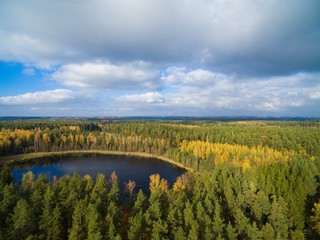 Aerial view of beautiful covered with forest landscape of Mazury region during autumn season, Ogonki, Poland