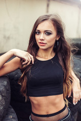 Gorgeous beauty model posing outdoors in street racing  with tires and cars on background. Speed, sport, beauty concept