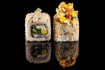 Concept of Asian cuisine. Two rolls of sushi with different fillings on a black background with the age for a Japanese menu for a cafe, restaurant, sushi bar.