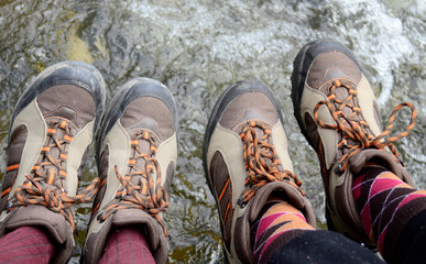 Legs of hikers with same boots  hanging