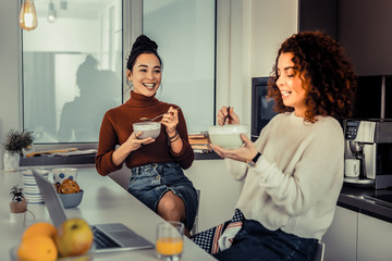 Two pretty roommates having delicious breakfast together