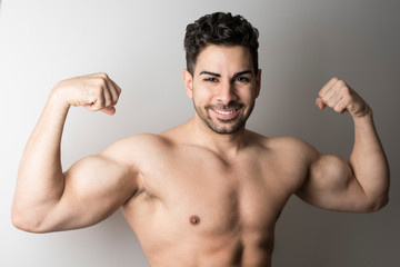 Obraz premium Strong attractive man posing and showing muscle looking at camera