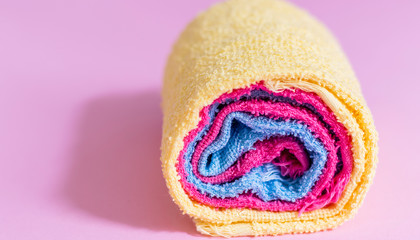 colored towels rolled up, pink background