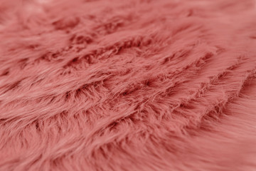 Pink fur background with lines. Pink sheepskin background and texture.