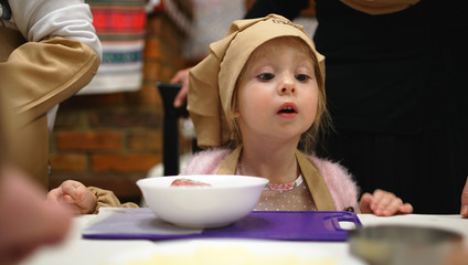 Little girl in a cooking caps playing in cafe. Concept of cooking classes