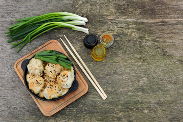 Dumplings with soy sauce and green onions in a cast iron skillet. Chinese dumplings.
