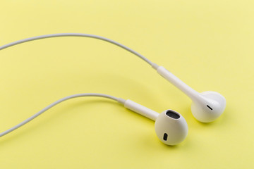 white earphones on yellow background.