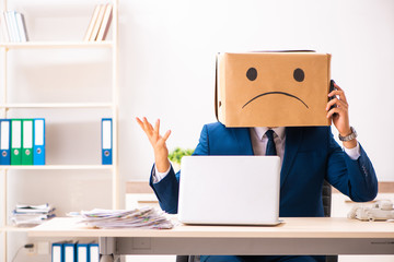 Unhappy man employee with box instead of his head