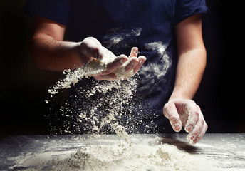 Baker with flour sifts through his hand