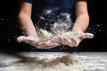 Male hands prepare bread, pie, pizza from flour. Hands cook throw flour.