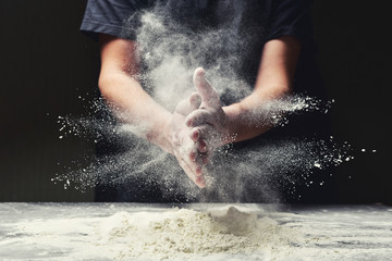 Clap hands of baker with flour in restaurant kitchen - obrazy, fototapety, plakaty