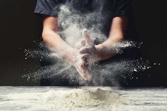 Clap hands of baker with flour in restaurant kitchen