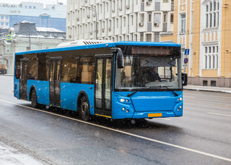 Fototapeta na wymiar Bus in winter in snowfall street