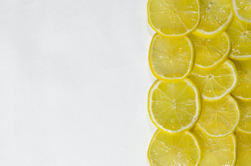 Thinly sliced lemon wedges lie on a white background