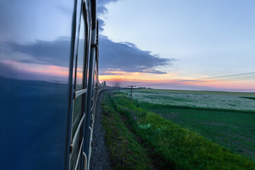 Motion of train at colorful sunset with clouds
