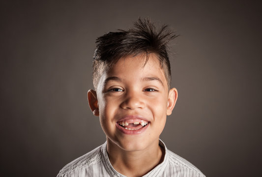 portrait of happy kid smiling on a grey background
