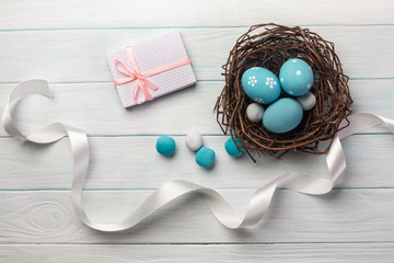 Blue painted eggs in nest and pussy willow. Easter greeting card. Top view with space for your greetings