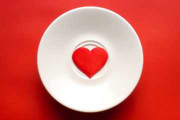 concept red heart at white dish. greeting card. copy space. relationships and humans. healthy lifestyle. for decor and design.