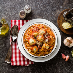 Italian pasta spaghetti with ricotta cheese balls in tomato sauce on the table with parmesan...