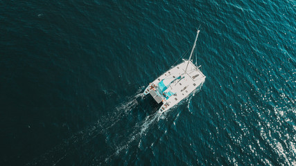 Aerial shot of beautiful blue lagoon at hot summer day with sailing boat. Top view.