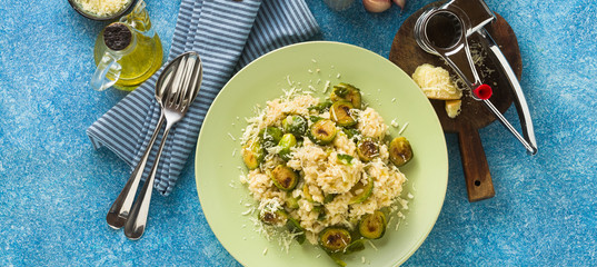 banner of Italian spring risotto with Brussels sprouts and parmesan cheese on the table. healthy food for the whole family, party or restaurant menu and red wine