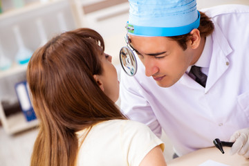 Fototapeta premium Young woman visting male doctor otolaryngologist