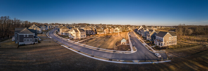 Aerial panorama of American luxury traditional, contemporary single family home estates with gable roof, in a new residential suburban new construction neighborhood for upper middle class USA families