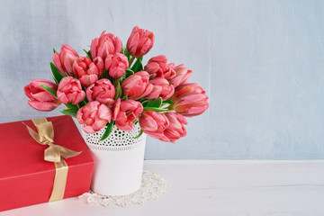 Pink tulups bouquet and red gift box. Valentine's Day, Birthday or Mother's Day concept. Copy space