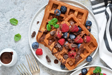 Belgian waffles with berries and chocolate sauce. View from above.