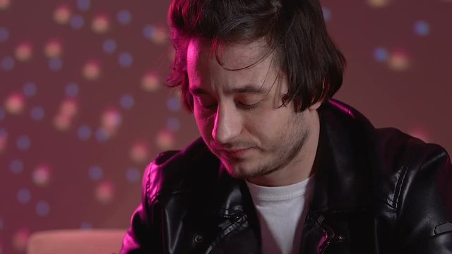 Young guy taking ecstasy pill to increase energy level at party, stimulation