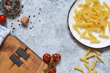 Italian food background. Pasta, tomatoes, parmesan and spices on a concrete background. Ingredient for cooking.