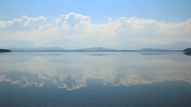 Cloudscape over blue waterfront of lake