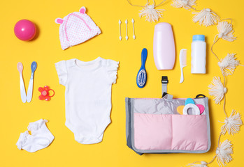 Flat lay composition with baby accessories and maternity bag on color background