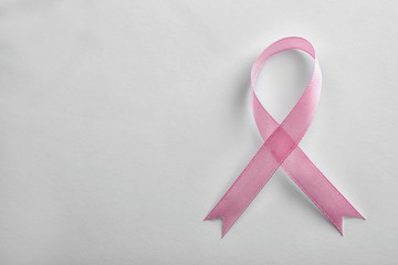 Pink ribbon on white background, top view with space for text. Breast cancer awareness concept