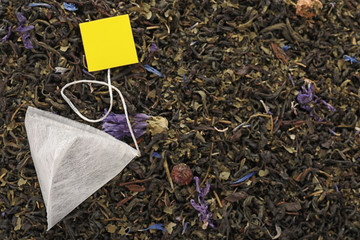 Tea bag on dry leaves, top view with space for text