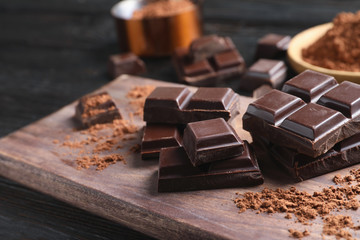 Pieces of black chocolate on wooden board