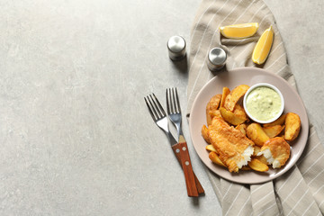 Plate with British Traditional Fish and potato chips on grey background, flat lay. Space for text