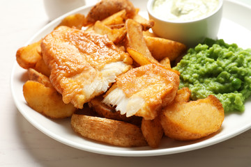 British Traditional Fish and potato chips on table, closeup