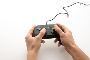 Young man holding video game controller on white background, closeup