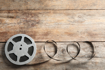 Obraz premium Movie reel on wooden background, top view with space for text. Cinema production