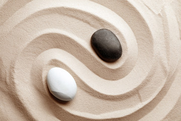 Zen garden stones on sand with pattern, top view. Meditation and harmony